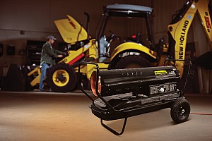 A New Holland Construction heater with a serviceman working on a loader in the background